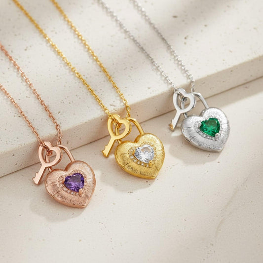 Three heart-shaped pendants on necklaces with different colored stones on a light background